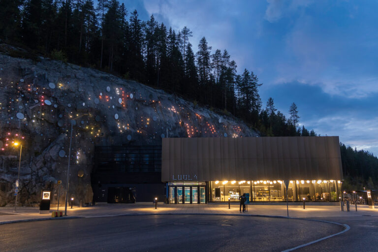 Luola, kallioon louhittu monitoimihalli, iltavalaistuksessaan.