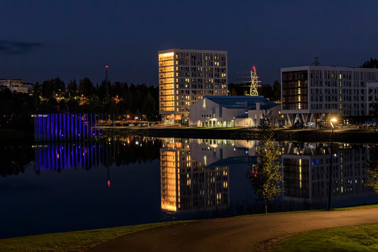 Talojen ja taideteosten valot loistavat pimeässä.