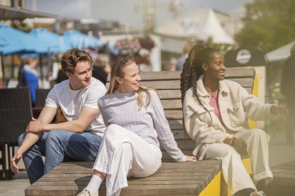 Kolme nuorta viettää aikaa torilla.